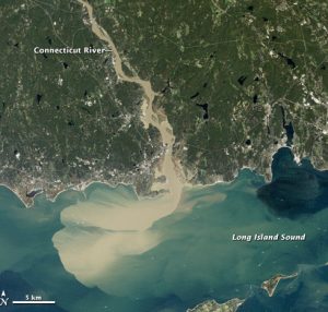 Аерознімок з Нової Англії, який показує впадіння повеневої річки в океан. Вода коричнева через наявність осаду